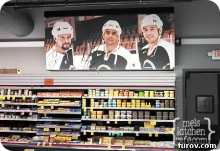 Hockey Hockey sticks and pucks used as decorative elements above a dairy aisle in a grocery store, reflecting local culture