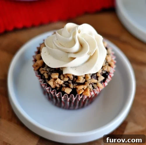 Golden Toffee Crunch Cupcakes 3 Top-down view of a perfectly frosted chocolate cupcake, generously adorned with toffee pieces, highlighting its delicious texture.