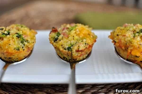 Ham, Broccoli & Cheddar Quinoa Poppers 2 Three cooked mini cheese and broccoli quinoa bites on spoons, showcasing their golden-brown exterior and wholesome ingredients.