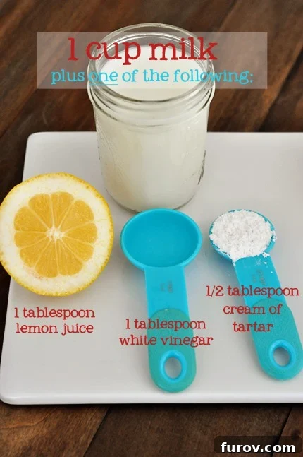 A white cutting board features a vibrant lemon, blue measuring spoons, and a mason jar filled with milk, suggesting the preparation of a homemade buttermilk substitute.