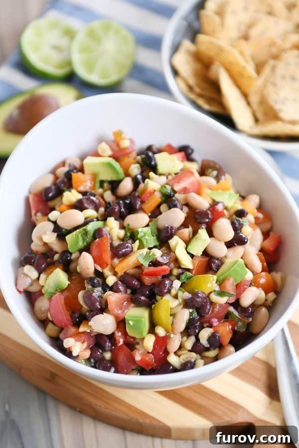 Zesty Cowboy Caviar Explosion 2 A bowl full of vibrant cowboy caviar dip, brimming with colorful beans, corn, and fresh vegetables, ready to be served.