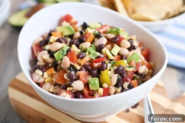 Zesty Cowboy Caviar Explosion 5 Close-up of cowboy caviar dip in a white bowl, ready to be enjoyed with tortilla chips.