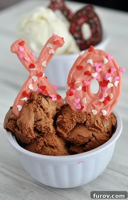 White bowl with chocolate ice cream and a pink chocolate sprinkled X and O nestled in the ice cream.