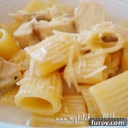 Top down view of a bowl of Lemon Cream Pasta with Chicken, garnished with fresh herbs and Parmesan.