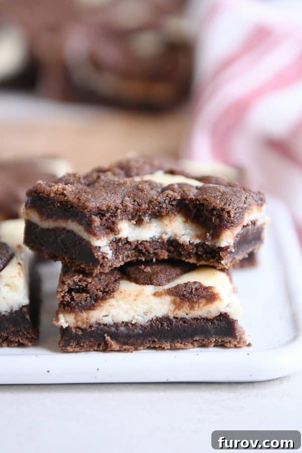 Ebony and Ivory Cheesecake Brownies 10 Black and white cheesecake brownies stacked on each other.