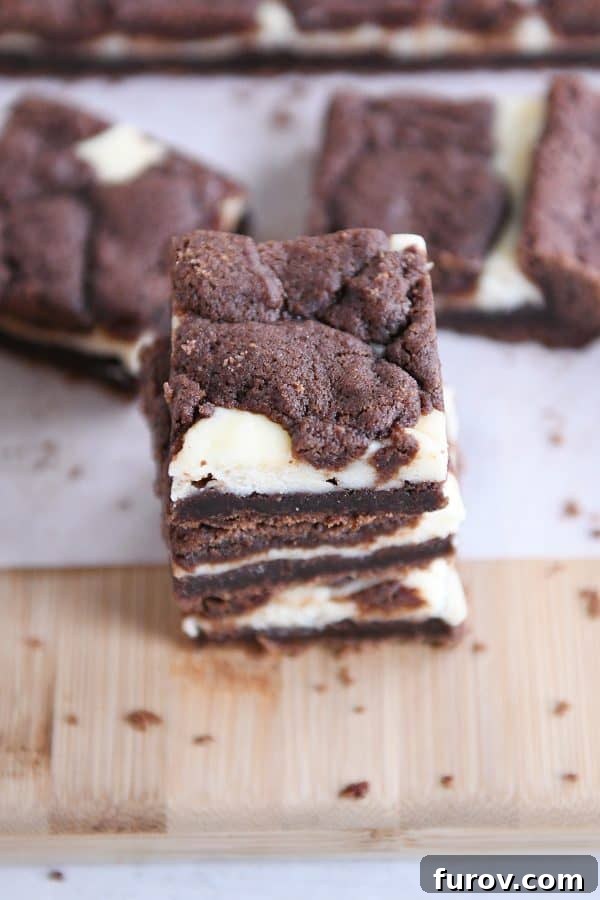 Ebony and Ivory Cheesecake Brownies 9 Black and white cheesecake brownies stacked on each other.
