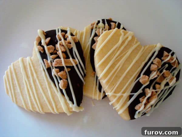 Chewy Chocolate Toffee Treasures 3 Three perfectly decorated heart-shaped chocolate-dipped sugar cookies, drizzled with white chocolate.