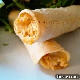 Close-up of baked chicken taquitos with a golden crisp exterior.