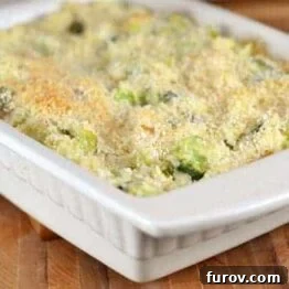 A dish of Cheesy Broccoli and Rice Casserole, presented in a rustic white bowl with a fork, ready to be enjoyed.