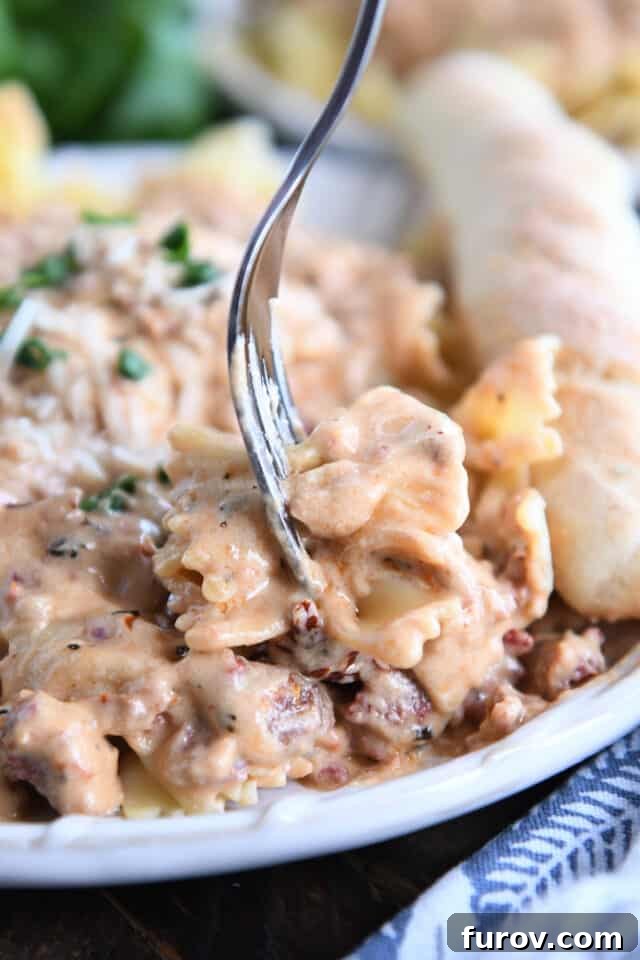 Velvety Tuscan Pasta Sauce Ready in 20 Minutes 5 A fork piercing several pieces of bowtie pasta generously coated in rich, creamy Tuscan pasta sauce.