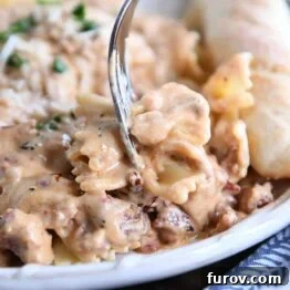 Velvety Tuscan Pasta Sauce Ready in 20 Minutes 6 A fork holding bowtie pasta with creamy sun-dried tomato pasta sauce.