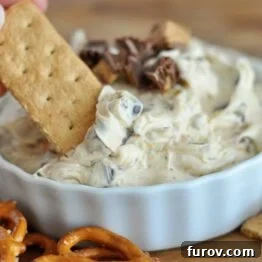 Peanut Butter Cookie Dough Dip in a white bowl with a graham cracker