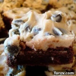 Close-up of a square of Cookie Dough Topped Brownie, showing the fudgy brownie base and creamy cookie dough layer with chocolate chips.
