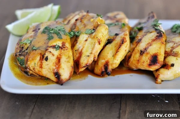 A pristine white rectangular platter elegantly displays perfectly grilled chicken, inviting and ready to serve.
