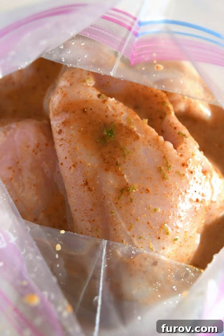 Chicken pieces submerged in the vibrant marinade, sealed within a ziplock bag, ready for refrigeration.