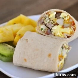 A small image of the breakfast burrito, split, with fresh fruit.