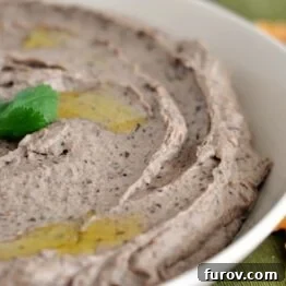 Zesty Black Bean Dip 3 A close-up shot of a small bowl of creamy black bean hummus, garnished with fresh cilantro.