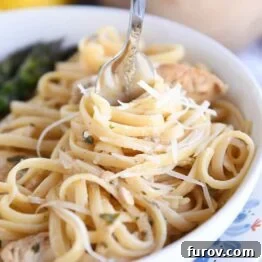 twisting pasta in white dish around fork