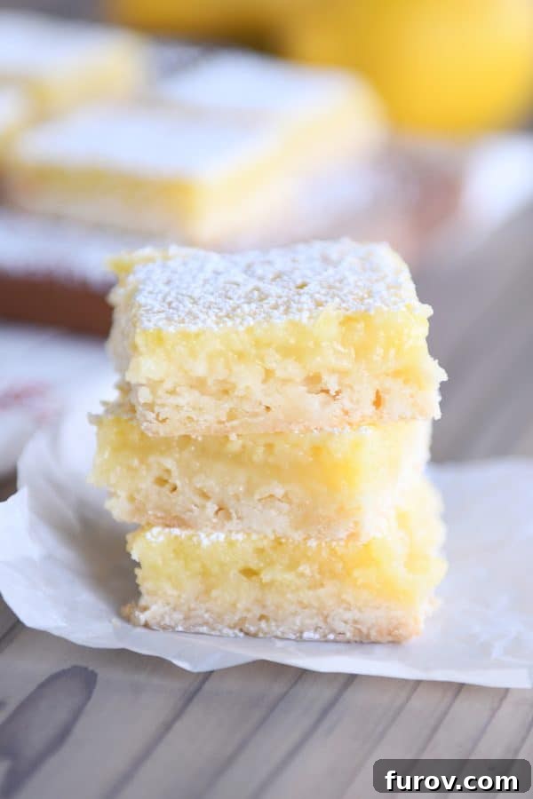 Three lemon bars stacked on top of each other.