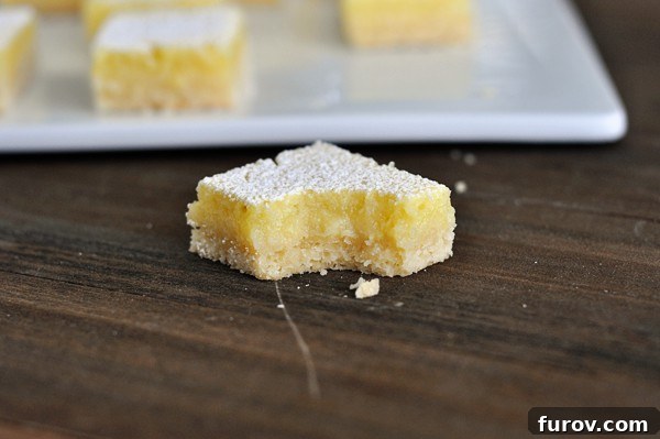 a square of lemon bar with a bite taken out
