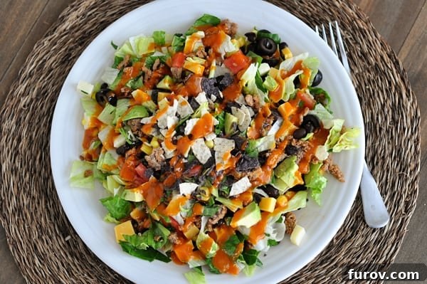 Zesty Chopped Taco Salad with Homemade Catalina 8 Top view of a white plate of taco salad with dressing drizzled on top, ready to be eaten.