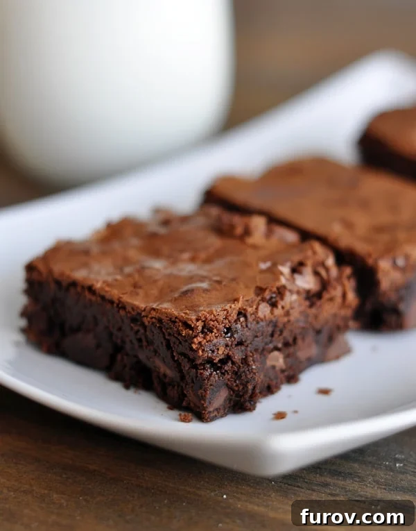 Perfectly cut Tappan Hill brownie squares neatly arranged on a white serving platter, ready to be enjoyed.