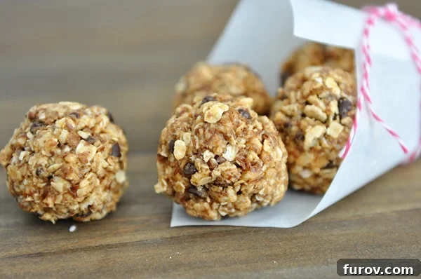 Chocolate chip granola bites spilling out of a white paper cone, showcasing their delicious appearance.