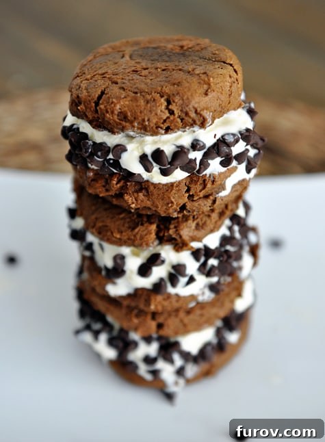Three decadent pumpkin chocolate chip ice cream sandwiches, stacked enticingly to show their layers of soft cookie and creamy filling.