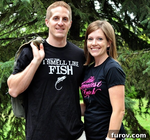 man and woman proudly wearing black fish-themed shirts, showcasing their shared love for angling