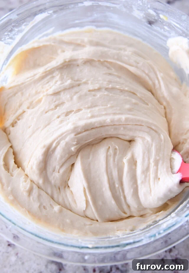 Vanilla cake batter swirled in glass bowl.
