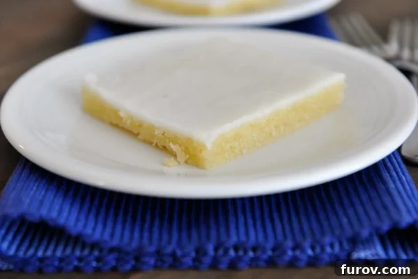 White plate with a piece of white texas sheet cake.