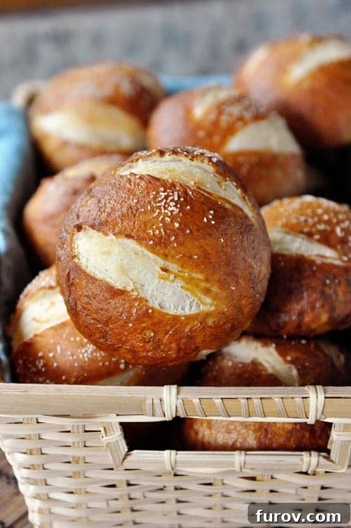 Pillowy Soft Pretzel Buns 2 A basket full of salted golden brown pretzel rolls, looking delicious and inviting.
