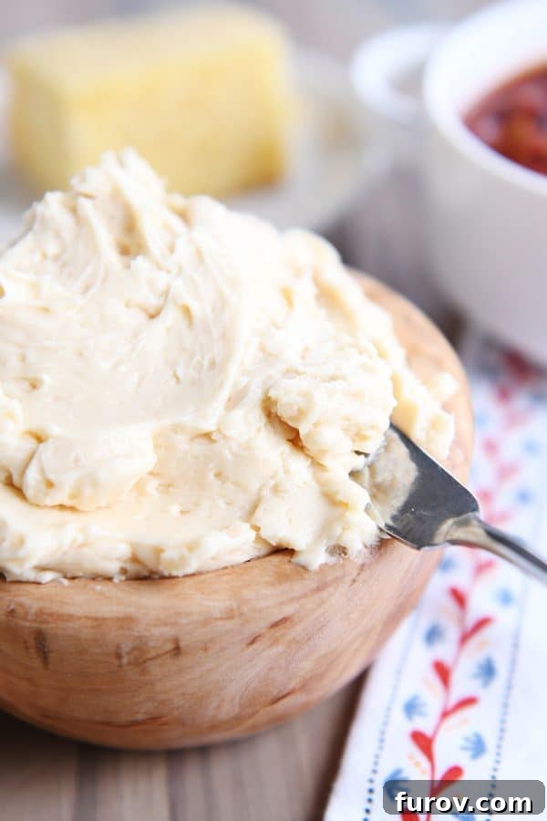 A wooden bowl generously filled with light and airy fluffy honey butter, ready to be served.