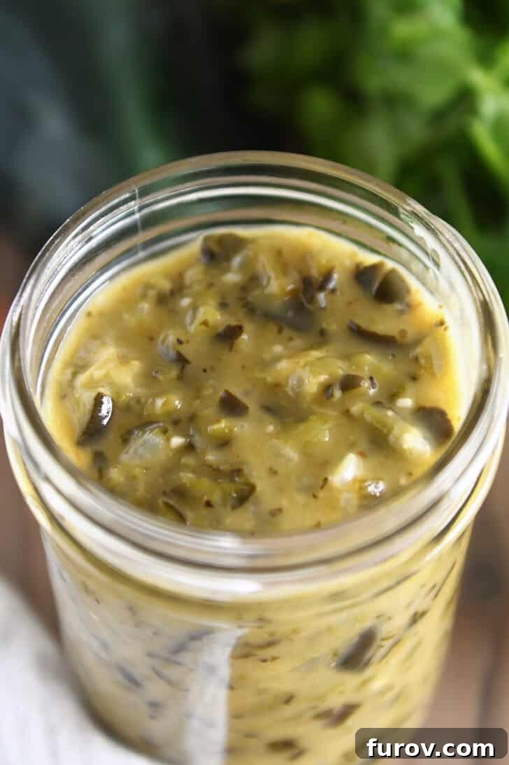 Top down view of a glass jar filled with luscious homemade green enchilada sauce, ready to be used or stored.