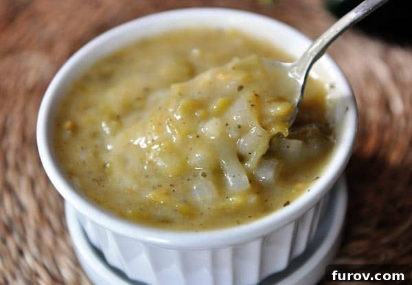 A spoon delicately scooping vibrant green enchilada sauce out of a small white ramekin, showcasing its perfect texture.