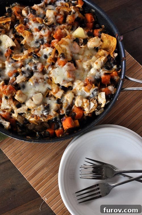 Top view of a cast iron skillet full of cheesy black bean enchilada casserole, showcasing the rich colors and melted cheese.