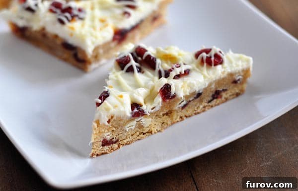 Cranberry bliss bars cut into triangle shapes on a white platter, ready to be served.