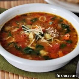 Tuscan Sausage and White Bean Soup garnished with Parmesan cheese.