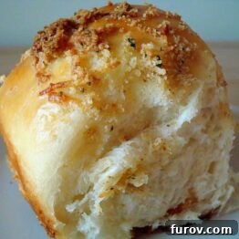 Delicious cheese rolls with a golden buttery parmesan crust on a cooling rack.