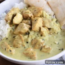 basil chicken in coconut curry sauce over rice with naan in white bowl