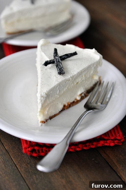White plate with a slice of vanilla white chocolate mousse cheesecake and a fork.
