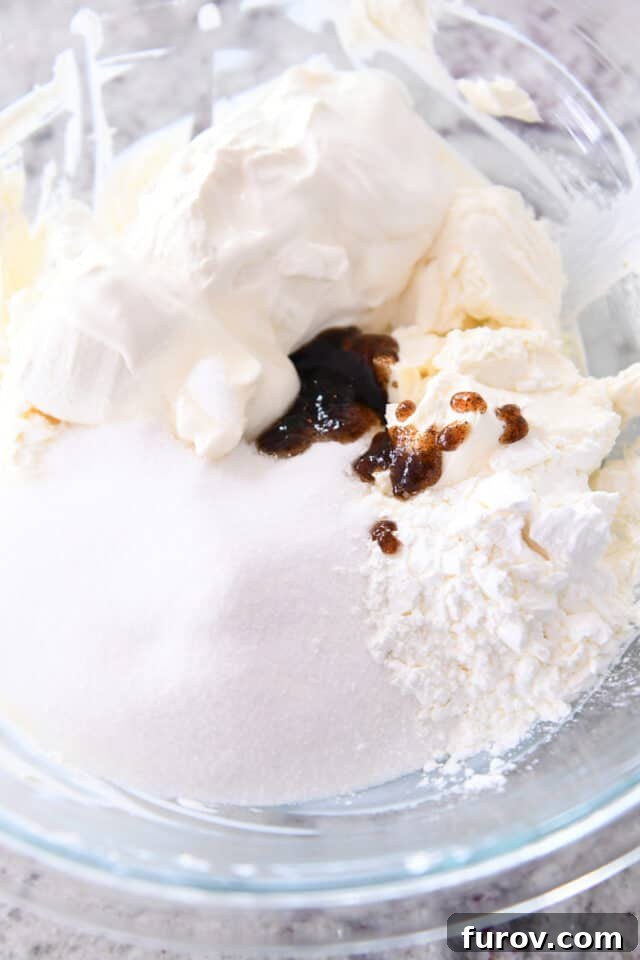 Sugar, cream cheese, cornstarch and vanilla bean paste in glass bowl.