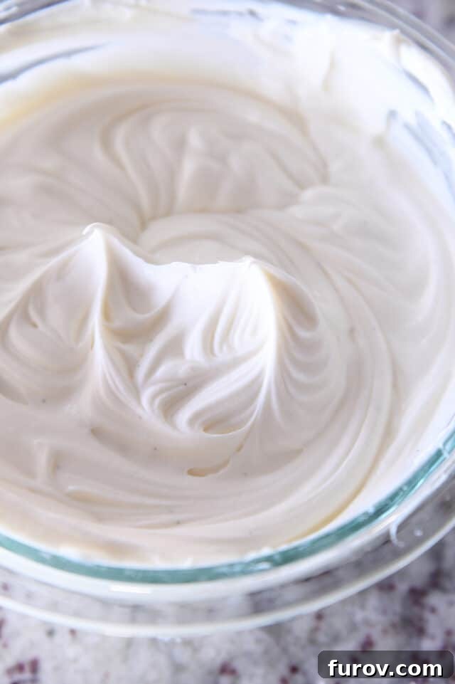 Whipped white chocolate mousse in glass bowl.