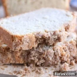 Two slices of cream cheese banana bread stacked on a wood cutting board, ready to be served.