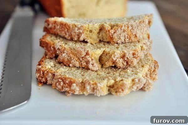 Three slices of streusel-topped banana bread stacked on top of each other on a white platter, ready to be served.