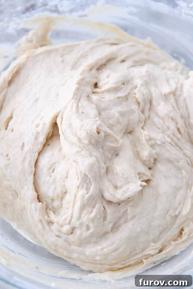 Thick and creamy banana bread batter in a glass bowl, showcasing its rich consistency.