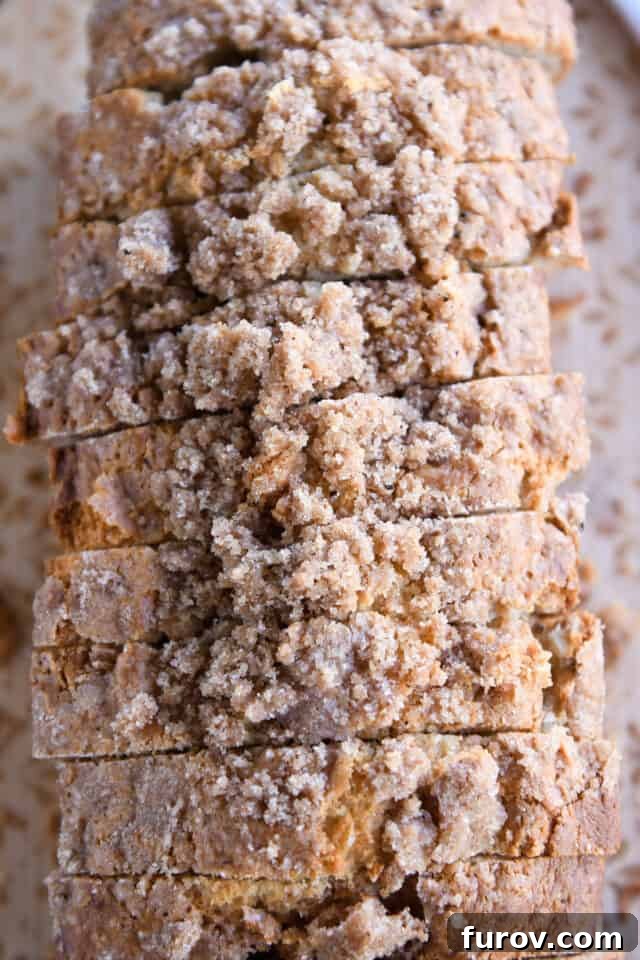 Top down view of seven perfectly sliced pieces of cream cheese banana bread with cinnamon streusel, arranged on a surface.