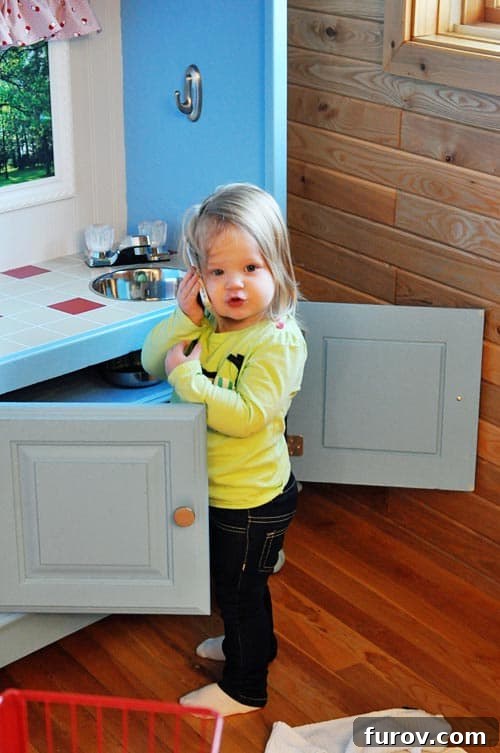 Cam playing happily with her new DIY upcycled play kitchen