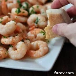 Close-up of a platter of shrimp scampi, emphasizing the texture and sauce.