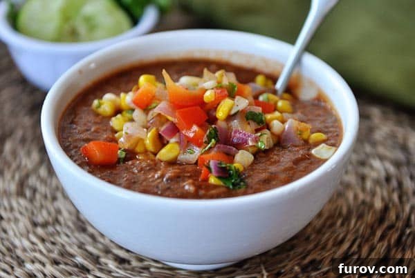 Hearty Smoky Tomato and Black Bean Soup with Zesty Corn Salsa 3 A close-up shot of the healthy Fire-Roasted Tomato and Black Bean Soup, showcasing the colorful corn and tomato salsa topping.